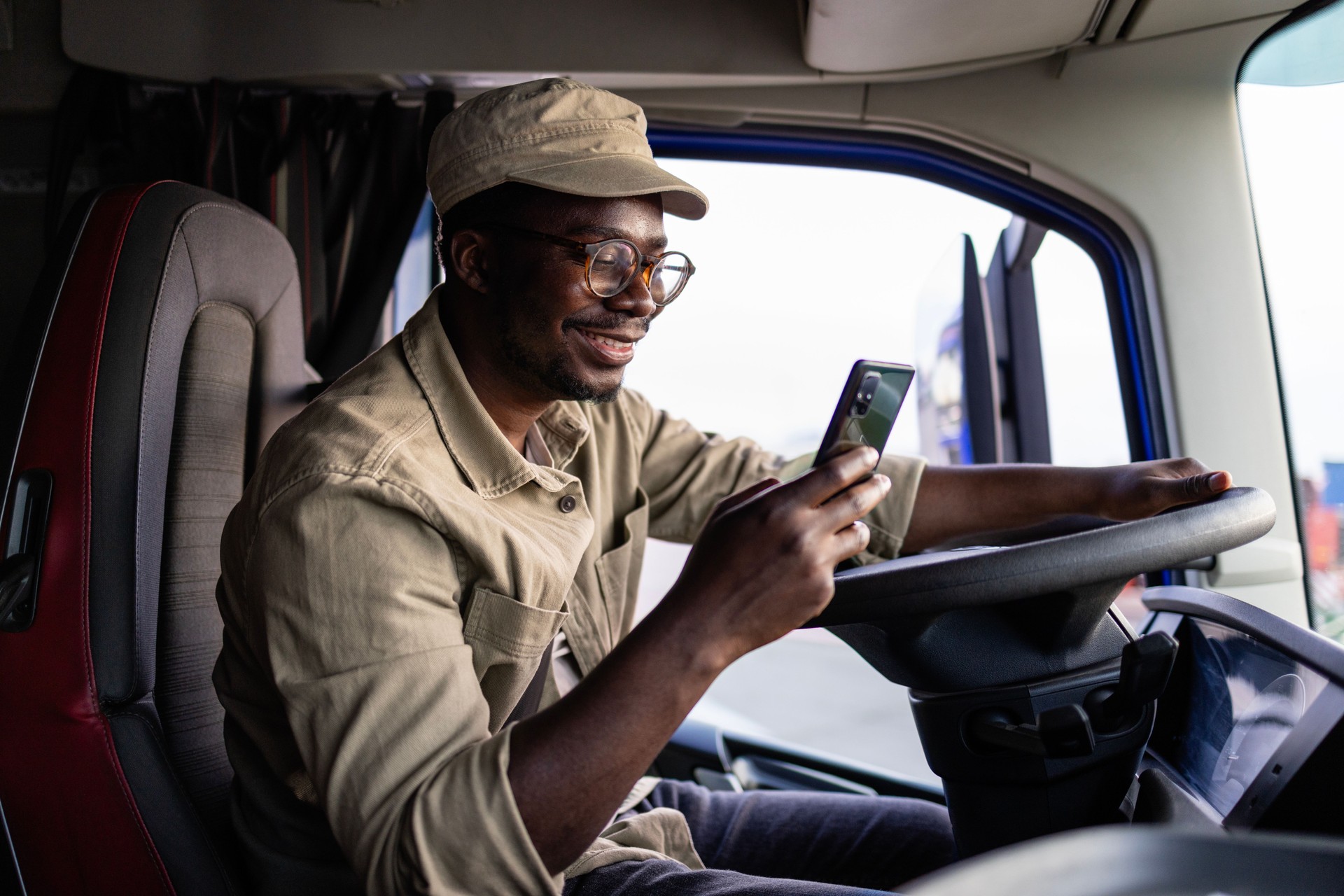 Truck driver texting message while cargo being unloaded.
